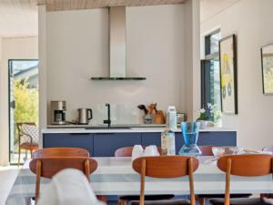 - une cuisine avec une table, des chaises et un comptoir dans l'établissement Holiday Home Gonne - 350m from the sea by Interhome, à Vester Sømarken