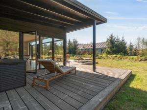 une terrasse en bois avec une chaise et une table dans l'établissement Holiday Home Gonne - 350m from the sea by Interhome, à Vester Sømarken 25 autres photos