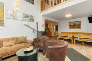 a living room with a couch and chairs and a table at Ferienhaus Eifel Atrium in Zweifelscheid