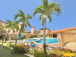 a resort with a swimming pool and palm trees at Vila do Mar - Porto das Dunas in Aquiraz
