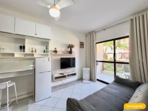 a kitchen and living room with a couch and a tv at Vila do Mar - Porto das Dunas in Aquiraz