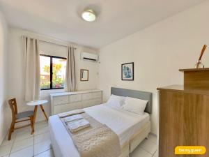 a bedroom with a bed and a chair and a window at Vila do Mar - Porto das Dunas in Aquiraz +26 photos