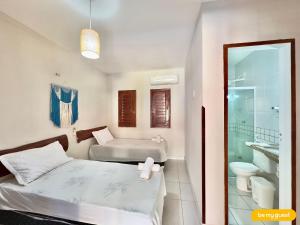 a bedroom with two beds and a bathroom at Casa Maresia em Flecheiras - 5 quartos e piscina in Curralinho +37 photos