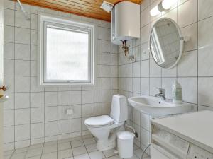 a bathroom with a toilet and a sink and a mirror at Holiday Home Gerty - 300m from the sea by Interhome in Vester Sømarken