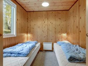 two beds in a room with wooden walls at Holiday Home Gerty - 300m from the sea by Interhome in Vester Sømarken