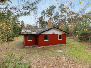 a red shed in the middle of a field at Holiday Home Gerty - 300m from the sea by Interhome in Vester Sømarken