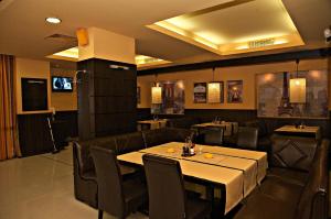 a dining room with a table and leather chairs at Hotel Serdica in Silistra