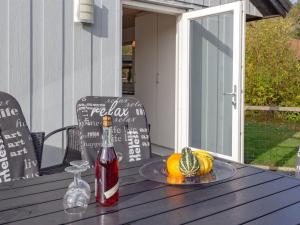 NeksøにあるHoliday Home Elisabeth - 400m from the sea by Interhomeのポーチのテーブルに置かれたワイン1本
