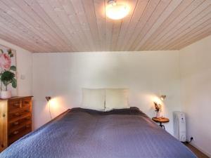 une chambre avec un grand lit avec un plafond en bois dans l'établissement Holiday Home Margarethe - 250m from the sea by Interhome, à Vester Sømarken