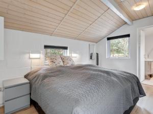 une chambre avec un grand lit et deux fenêtres dans l'établissement Holiday Home Margarethe - 250m from the sea by Interhome, à Vester Sømarken 14 autres photos