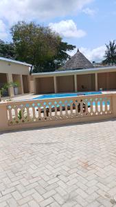 a fence in front of a building with a swimming pool at Imani stay cations Diani in Diani Beach