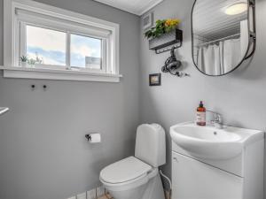 a bathroom with a toilet and a sink and a mirror at Apartment Helemine - 2-8km from the sea by Interhome in Gudhjem +16 photos