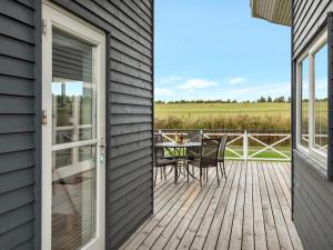 a patio with a table and chairs on a deck at Apartment Helemine - 2-8km from the sea by Interhome in Gudhjem