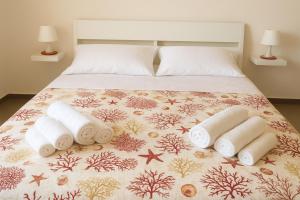a bed with a bunch of rolled towels on it at Villa Adele Monopoli,Puglia in Faccia di Trippa
