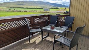 two chairs and a table on a balcony with a view at Staðarhóll Guesthouse room A in Þingeyjarsveit