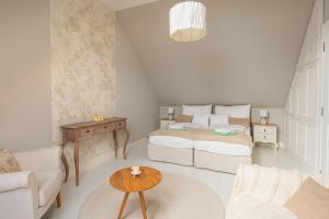 a living room with two beds and a table at Herczeg-Fekete Cottage Birtokközpont in Simontornya +111 photos