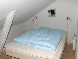 un letto con una coperta blu sopra di Apartment Thorsten - 500m from the sea by Interhome ad Allinge