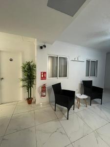 a room with two chairs and a table and a plant at Pensiòn Cerdà 112 in Alicante