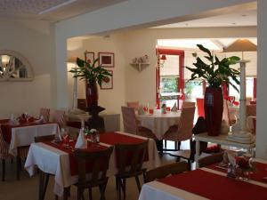 a dining room with tables and chairs and vases at Hotel Restaurant Aux Sapins in Thann