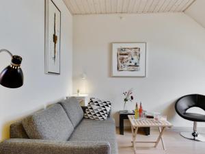 a living room with a couch and a table at Apartment Gulla - 300m from the sea by Interhome in Gudhjem