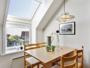 a dining room with a table and a window at Apartment Gulla - 300m from the sea by Interhome in Gudhjem +11 photos