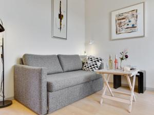 a living room with a couch and a table at Apartment Gulla - 300m from the sea by Interhome in Gudhjem