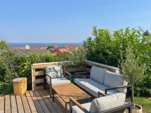 a patio with two chairs and a couch on a deck at Holiday Home Jolanda - 800m from the sea by Interhome in Gudhjem