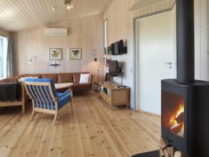 a living room with a couch and a fireplace at Holiday Home Jolanda - 800m from the sea by Interhome in Gudhjem +13 photos
