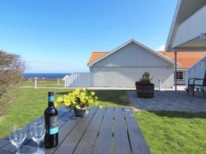 una bottiglia di vino e bicchieri su un tavolo di legno di Apartment Hunter - 400m from the sea by Interhome ad Allinge