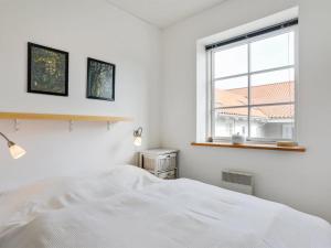 una camera da letto bianca con un letto e una finestra di Apartment Hunter - 400m from the sea by Interhome ad Allinge