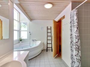 a bathroom with a tub and a toilet and a sink at Holiday Home Verner - 500m from the sea by Interhome in Hasle