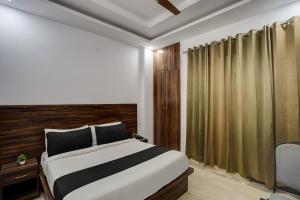 Un dormitorio con una cama grande y una silla en Townhouse Cloud Bay, en Gurgaon