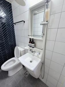 a white bathroom with a toilet and a sink at K-WON Stay in Seoul