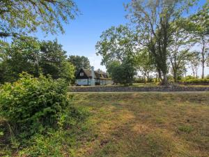 a house in the middle of a field with trees at Holiday Home Nyyrikki - 100m from the sea by Interhome in Gudhjem