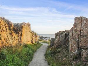 un sentiero tra due grandi rocce vicino all'oceano di Apartment Ayk - 400m from the sea by Interhome ad Allinge