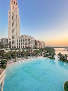 a large swimming pool in a city with buildings at FIRST CLAS 1BR Creek Beach , Lagoon Access in Dubai