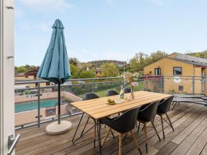 a wooden table and chairs on a balcony with a view at Apartment Hermann - 100m from the sea by Interhome in Allinge