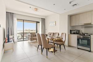 a kitchen and dining room with a table and chairs at FIRST CLAS 1BR Creek Beach , Lagoon Access in Dubai