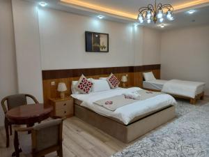 a bedroom with a bed and a table and a desk at FARIZ Hotel in Panjakent +10 photos