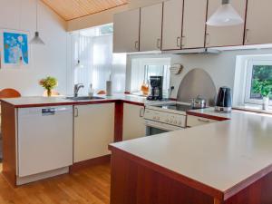 a kitchen with white cabinets and a white counter top at Holiday Home Dilan - 600m from the sea by Interhome in Hasle +13 photos