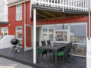a patio with a table and chairs and a grill at Holiday Home Eija - 5m from the sea by Interhome in Hasle