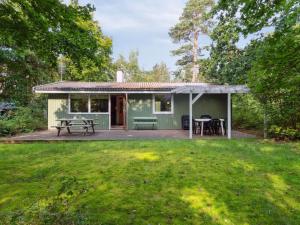 a green cottage with a picnic table in a yard at Holiday Home Joske - 250m from the sea by Interhome in Hasle