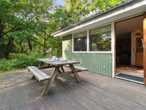 a picnic table on a deck next to a house at Holiday Home Joske - 250m from the sea by Interhome in Hasle