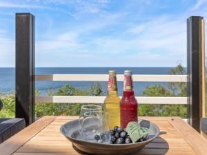 a table with two bottles and a bowl of grapes at Holiday Home Thormoth - 200m from the sea by Interhome in Hasle