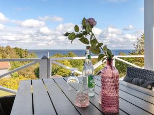 a wooden table with two bottles and a vase at Holiday Home Tjelle - 300m from the sea by Interhome in Allinge