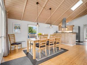 a kitchen and dining room with a wooden table and chairs at Holiday Home Alger - 800m from the sea by Interhome in Marielyst