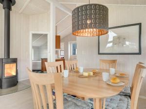 une salle à manger avec une table et un lustre dans l'établissement Holiday Home Birtir - 1-2km from the sea by Interhome, à Bøtø By