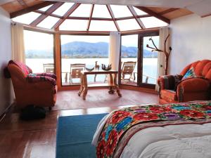 プーノにあるTiticaca Lodge Flotanteのベッドがあり水辺の景色が見える寝室