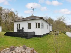 a small white house in a grassy yard at Holiday Home Ensio - 150m from the sea by Interhome in Allinge