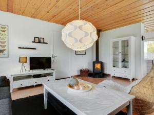 a living room with a table and a fireplace at Holiday Home Arnulf - 400m from the sea by Interhome in Marielyst
